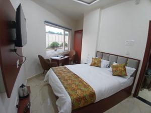 een slaapkamer met een groot bed en een raam bij The Millennium Kashi Hotel in Varanasi