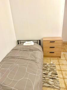 a bedroom with a bed and a wooden dresser at Maison Bon Séjour in Livry-Gargan