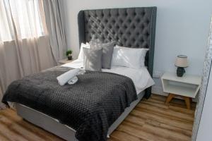 Un dormitorio con una cama grande con un animal de peluche encima. en Twilight Self Catering, en Windhoek
