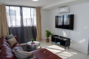 Una sala de estar con un sofá y un televisor de pantalla plana. en Twilight Self Catering, en Windhoek