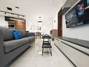 a living room with a couch and a tv at Valley View 2 in Luqa