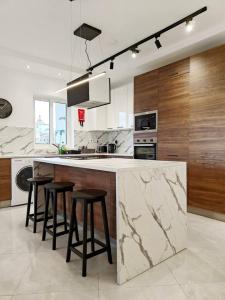 a large kitchen with a marble counter and stools at Valley View 1 in Luqa