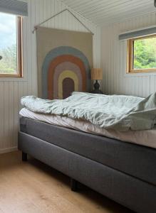 a bedroom with a bed with a rainbow on the wall at Wonderful Family House At The West Coast in Løkken