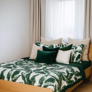 Una cama con almohadas verdes y blancas. en TK Apartments Namysłów, en Namysłów