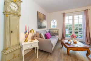 a living room with a couch and a clock at Altstadttor 17 in Westerland
