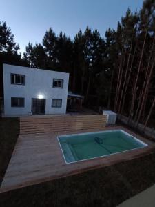 a backyard with a swimming pool and a house at Cabañas del Sol in Punta Del Diablo +15 photos