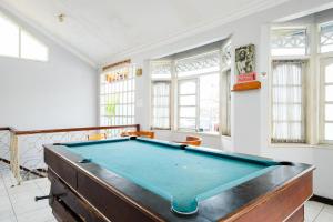 a pool table in a room with windows at RedDoorz Plus @ Mahendradatta Denpasar in Denpasar