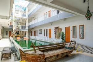 a pool in a building with a bench next to it at RedDoorz Plus @ Mahendradatta Denpasar in Denpasar