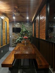 a wooden table in a room with a stone wall at Villa Cô Ba 2 in Da Thanh +62 photos