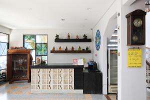 a store with a counter with a clock on the wall at RedDoorz Plus @ Mahendradatta Denpasar in Denpasar