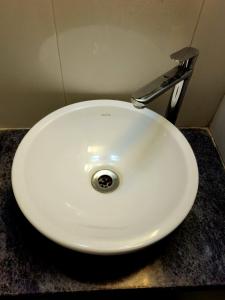 un évier blanc avec un robinet en argent sur un comptoir dans l'établissement Antidote Villa 3BHK ll Swimming Pool ll Snooker Tab ll AC ll BBQ, à Lonavala