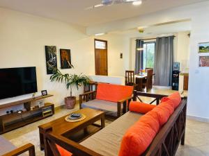 a living room with a couch and a television at Casa Nampala Diani in Ukunda