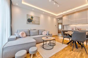 ein Wohnzimmer mit Sofa und Tisch in der Unterkunft Apartmani Gomax 3,4 & SPA Zlatibor in Zlatibor