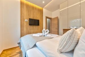 ein Schlafzimmer mit einem Bett mit zwei Handtüchern darauf in der Unterkunft Apartmani Gomax 3,4 & SPA Zlatibor in Zlatibor