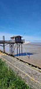 a pier with a house on it on the beach at Le Cocon Terracotta & Spa in Saint-Laurent-de-Médoc
