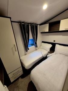 two beds in a small room with a window at Sirrah Villa - Whitstable, Family & Pet friendly in Seasalter