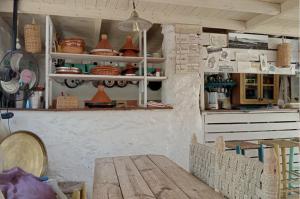 a kitchen with a wooden table in a room at Bed0Bled Cabanes & Holiday homes in Sidi Kaouki