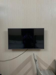 a television hanging on a wall with a chair at LushStay Cao Bá Quát in Hanoi