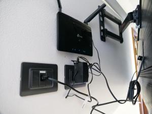 a tv on a wall with a charger and a adapter at LaTanaDiFedro - Monolocale tra centro storico e mare in Grado