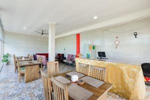 a restaurant with tables and chairs and a bar at Urbanview Ava Guest House Goa Gong in Jimbaran