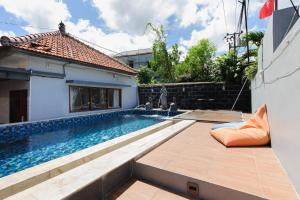 a swimming pool in the backyard of a house at Urbanview Ava Guest House Goa Gong in Jimbaran