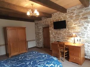 a bedroom with a bed and a desk and a tv at Chambre double chez Emilienne 