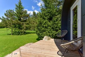 a wooden deck with two chairs on a house at Mileikių sodyba namelis dviems in Šarkiškės
