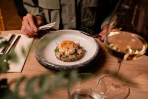 a person sitting at a table with a plate of food at Slow Living bij Mölke x Wellnesslodges in Zuna