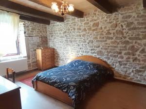 a bedroom with a bed with a stone wall at Chambre double chez Emilienne in Téterchen