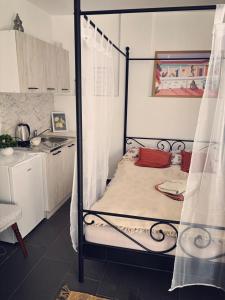 a bedroom with a four poster bed and a kitchen at Valencia in Vršac