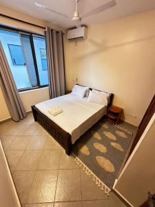 a bedroom with a bed and a large window at Casa Nampala Diani in Ukunda