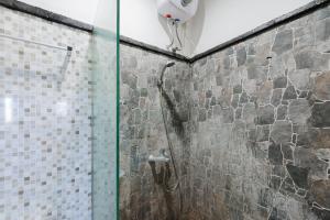a shower with a glass door in a bathroom at Gita Inn Bali RedPartner in Denpasar