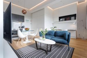 a living room with a blue couch and a table at Penthouse-Flair with Skyline-View in Vienna