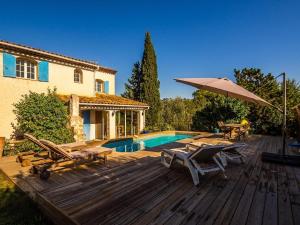 a deck with chairs and an umbrella next to a pool at 3 Bedroom 2 Bath Villa Private Pool in Mougins in Mougins