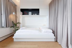a bedroom with two white beds and a window at Penthouse-Flair with Skyline-View in Vienna