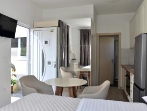 a room with a table and chairs and a kitchen at Apartments and Rooms Tomas in Podstrana