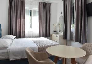 a bedroom with a bed and a table and chairs at Apartments and Rooms Tomas in Podstrana