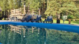 a group of chairs sitting next to a swimming pool at Purgaiļi in Smiltene