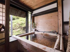 una stanza con pareti in legno e una grande finestra di Yokohama Fujiyoshi Izuten a Ito
