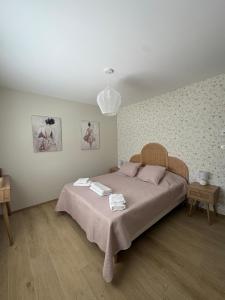 ein Schlafzimmer mit einem großen Bett mit rosa Bettwäsche und einer Lampe in der Unterkunft Villa des Roches - Labeaume in Labeaume + 19 Fotos