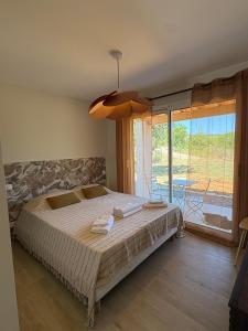 ein Schlafzimmer mit einem großen Bett und einem großen Fenster in der Unterkunft Villa des Roches - Labeaume in Labeaume