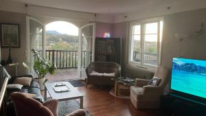 a living room with a television and a balcony at Villa bord de mer Pays Basque Bidart - Biarritz - Guethary - St Jean de Luz in Bidart