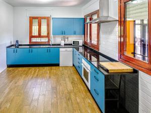 Una cocina grande con gabinetes azules y pisos de madera. en Casa Viria, en Navaluenga