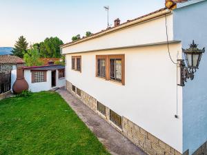 una casa blanca con una pared y un patio en Casa Viria, en Navaluenga