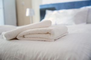 a stack of white towels sitting on a bed at Γκαρσονιέρα 1 δίπλα στη θάλασσα! in Antikyra