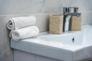 a bathroom sink with towels and a faucet at Γκαρσονιέρα 1 δίπλα στη θάλασσα! in Antikyra +13 photos