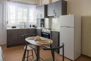 a kitchen with a table and a white refrigerator at Γκαρσονιέρα 1 δίπλα στη θάλασσα! in Antikyra