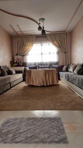una sala de estar con una mesa y un sofá en appartement luxe, en Berkane