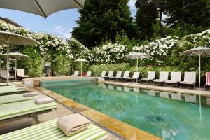 ein Swimmingpool mit Liegestühlen und Sonnenschirmen in der Unterkunft Ville Sull'Arno - Preferred Hotels & Resorts in Florenz