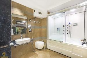 a bathroom with a toilet and a sink and a shower at Shady Oaks by Stay Pattern in Srinagar +25 photos